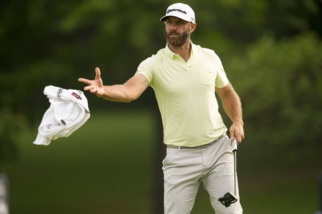 Dustin Johnson tosses his towel to his caddie on the 10th hole during the second round of the PGA C...