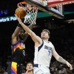 
              Dallas Mavericks guard Luka Doncic (77) tries to get off a shot against Phoenix Suns center Deandre Ayton (22) during the first half of Game 5 of an NBA basketball second-round playoff series Tuesday, May 10, 2022, in Phoenix. (AP Photo/Ross D. Franklin)
            