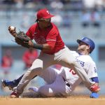 
              Philadelphia Phillies second baseman Jean Segura (2) throws to first for a double play during the fourth inning of a baseball game against the Los Angeles Dodgers in Los Angeles, Sunday, May 15, 2022. Los Angeles Dodgers' Max Muncy (13) was out at second and Justin Turner was out at first. (AP Photo/Ashley Landis)
            
