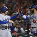 
              Los Angeles Dodgers' Freddie Freeman, left, gets a high-five from Edwin Rios (43) after scoring on a single by Trea Turner during the sixth inning of a baseball game against the Washington Nationals, Monday, May 23, 2022, in Washington. (AP Photo/Nick Wass)
            