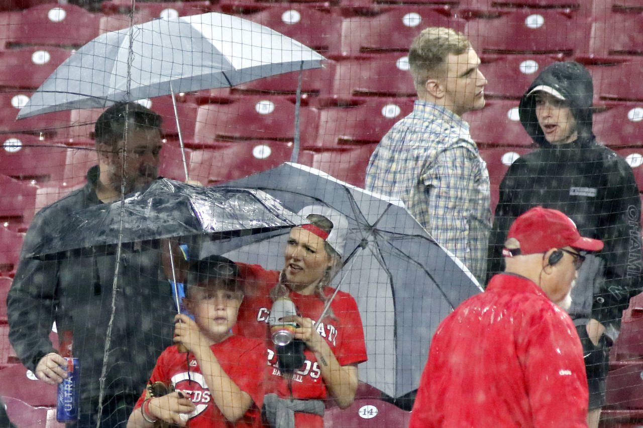 Fans put up their umbrellas as rain begins to fall in the stands after the Pittsburgh Pirates again...