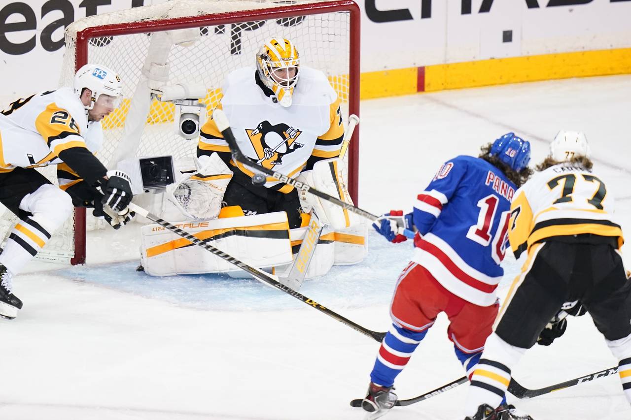 Pittsburgh Penguins goaltender Louis Domingue (70) stops a shot on goal by New York Rangers' Artemi...