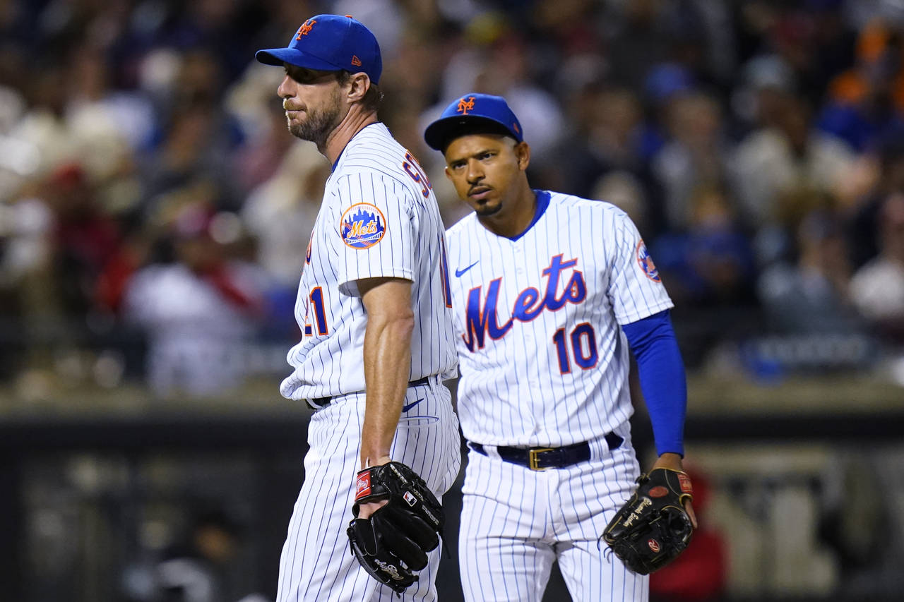 New York Mets third baseman Eduardo Escobar (10) checks on starting pitcher Max Scherzer during the...