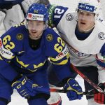 
              Sweden's Joel Kellman, left, and Norway's Christian Bull eye for the puck during the 2022 IIHF Ice Hockey World Championships preliminary round group B match between Sweden and Norway, in Tampere, Finland, Sunday, May 22, 2022. (Jussi Nukari/Lehtikuva via AP)
            
