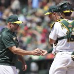 
              Oakland Athletics manager Mark Kotsay, left, receives the ball from starting pitcher James Kaprielian during the third inning of a baseball game against the Cleveland Guardians in Oakland, Calif., Sunday, May 1, 2022. (AP Photo/Darren Yamashita)
            
