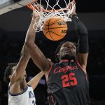 
              Houston center Josh Carlton dunks in front of Villanova forward Jermaine Samuels during the first half of a college basketball game in the Elite Eight round of the NCAA tournament on Saturday, March 26, 2022, in San Antonio. (AP Photo/David J. Phillip)
            