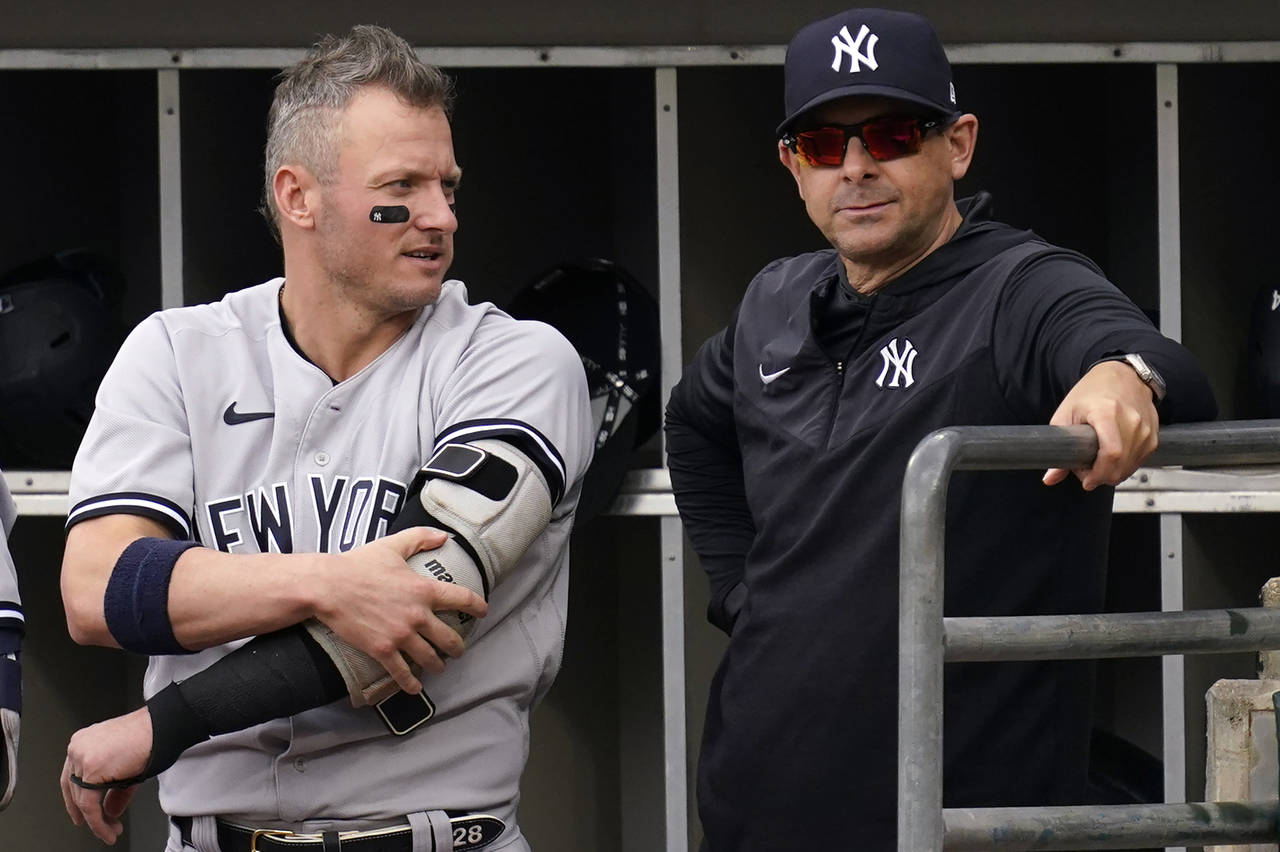 New York Yankees' Josh Donaldson, left, talks with manager Aaron Boone in the dugout during the fir...