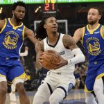 
              Memphis Grizzlies guard Ja Morant, center, handles the ball between Golden State Warriors forward Andrew Wiggins (22) and guard Stephen Curry (30) during Game 1 of a second-round NBA basketball playoff series Sunday, May 1, 2022, in Memphis, Tenn. (AP Photo/Brandon Dill)
            