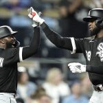
              Chicago White Sox's Luis Robert, right, celebrates with Josh Harrison (5) after hitting a two-run home run during the tenth inning of a baseball game against the Kansas City Royals Monday, May 16, 2022, in Kansas City, Mo. (AP Photo/Charlie Riedel)
            