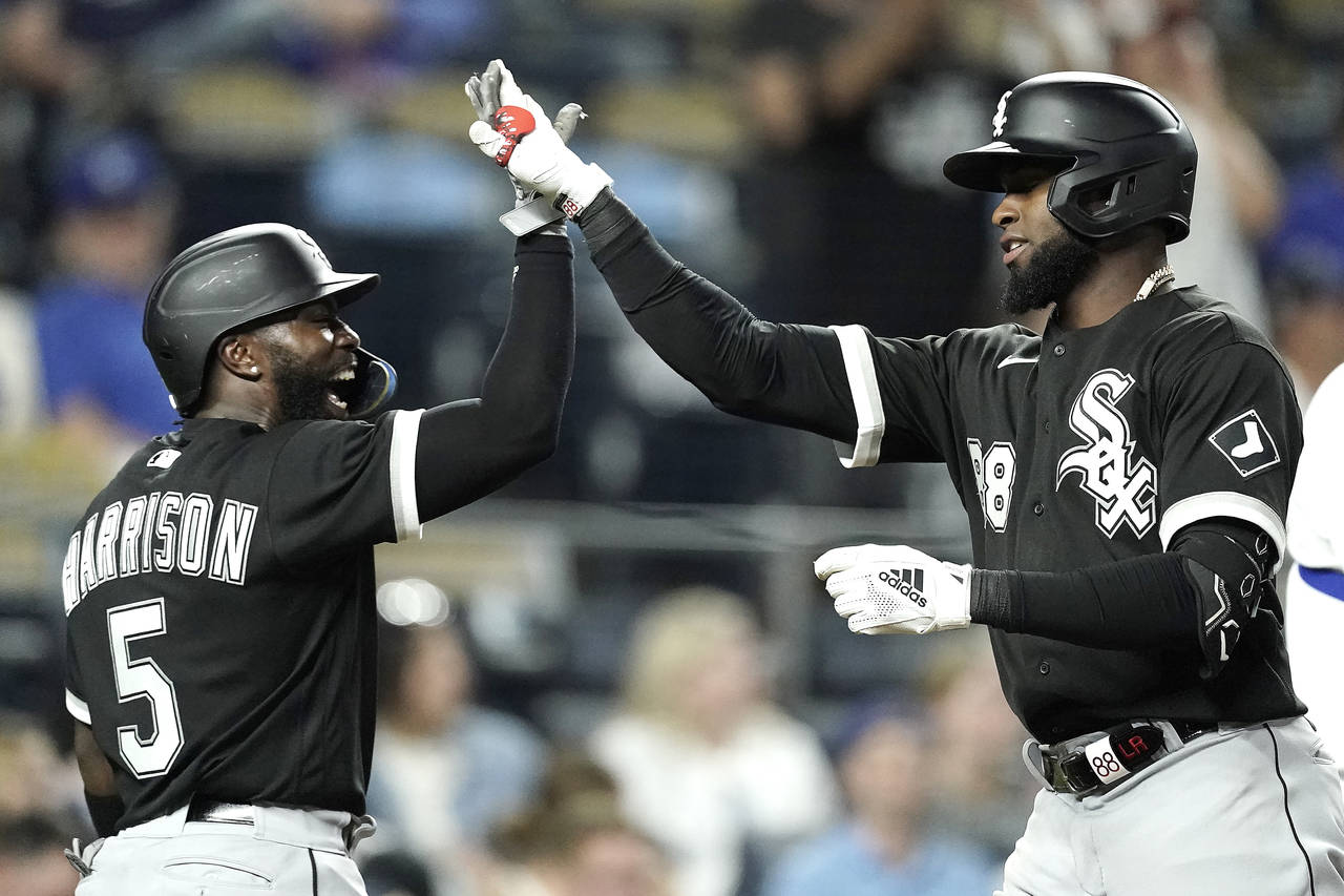 Chicago White Sox's Luis Robert, right, celebrates with Josh Harrison (5) after hitting a two-run h...