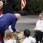 
              President Joe Biden and first lady Jill Biden stop to pet a service dog as they arrive for an event with the Tokyo 2020 Summer Olympic and Paralympic Games, and Beijing 2022 Winter Olympic and Paralympic Games, on the South Lawn of the White House, Wednesday, May 4, 2022, in Washington. (AP Photo/Evan Vucci)
            