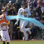 
              Oakland Athletics' Luis Barrera (13) jumps through Gatorade thrown by Tony Kemp (5) after hitting a three-run home run against the Los Angeles Angels during the ninth inning of the first baseball game of a doubleheader in Oakland, Calif., Saturday, May 14, 2022. (AP Photo/Jeff Chiu)
            