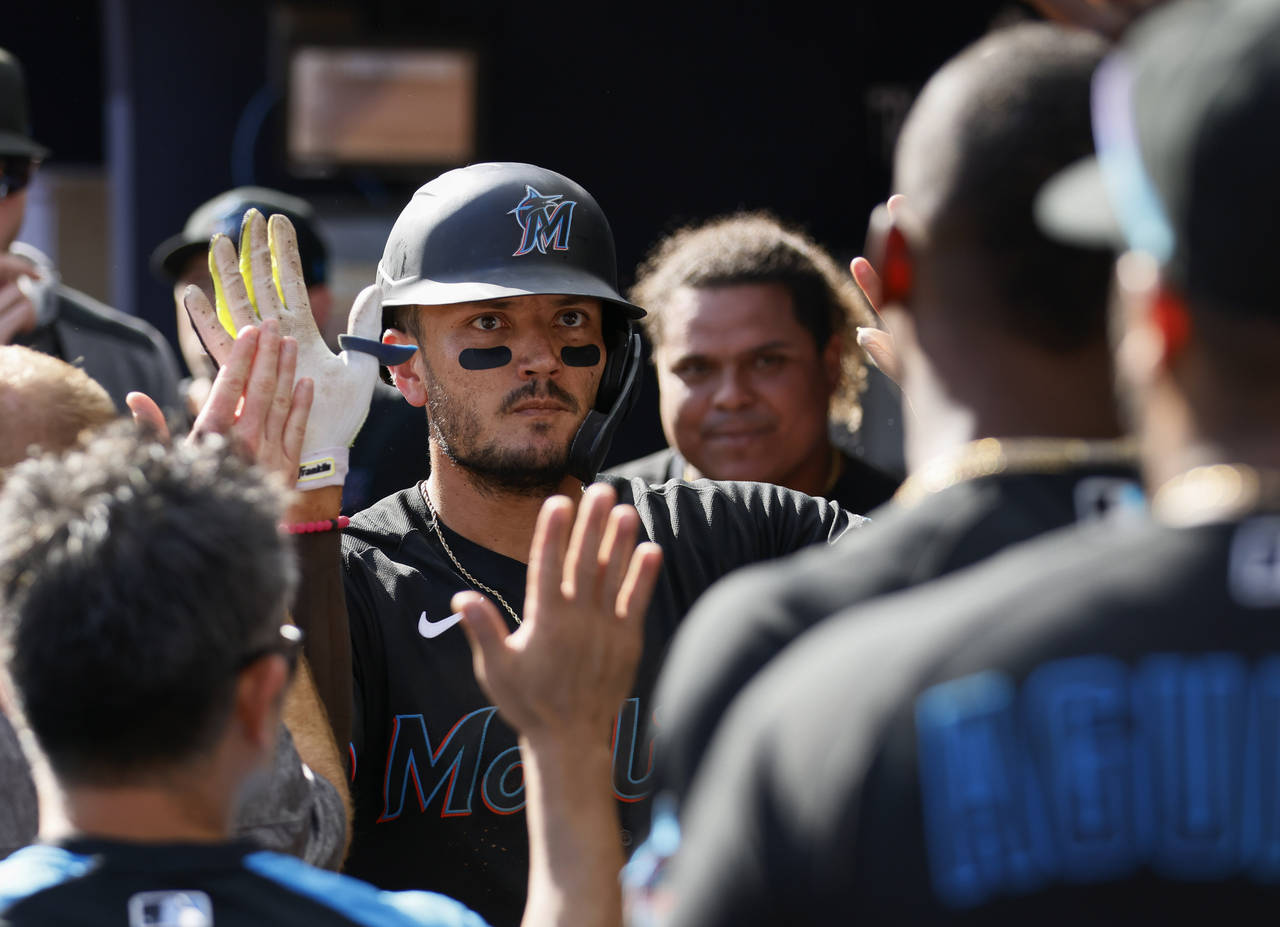 Marlins' Miguel Rojas is congratulated after his sixth-inning home run against the Atlanta Braves i...