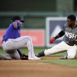 
              Washington Nationals' Victor Robles, right, steals second as Colorado Rockies shortstop Jose Iglesias tries to make the tag during the fifth inning of the second baseball game of a doubleheader Saturday, May 28, 2022, in Washington. (AP Photo/Nick Wass)
            