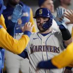 
              Seattle Mariners' Luis Torrens is greeted in the dugout after he slid safely home to score on a RBI single hit by Ty France during the sixth inning of a baseball game against the Houston Astros, Sunday, May 29, 2022, in Seattle. (AP Photo/Ted S. Warren)
            