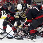 
              Boston Bruins' Charlie Coyle (13) battles between Carolina Hurricanes' Teuvo Teravainen (86) and Brendan Smith (7) during the first period of Game 1 of an NHL hockey Stanley Cup first-round playoff series in Raleigh, N.C., Monday, May 2, 2022. (AP Photo/Karl B DeBlaker)
            