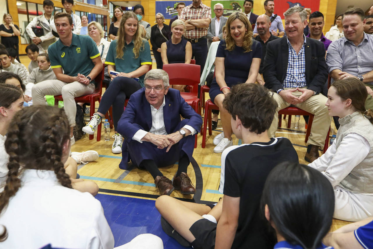 International Olympic Committee President Thomas Bach, center, speaks with young athletes at the Ol...