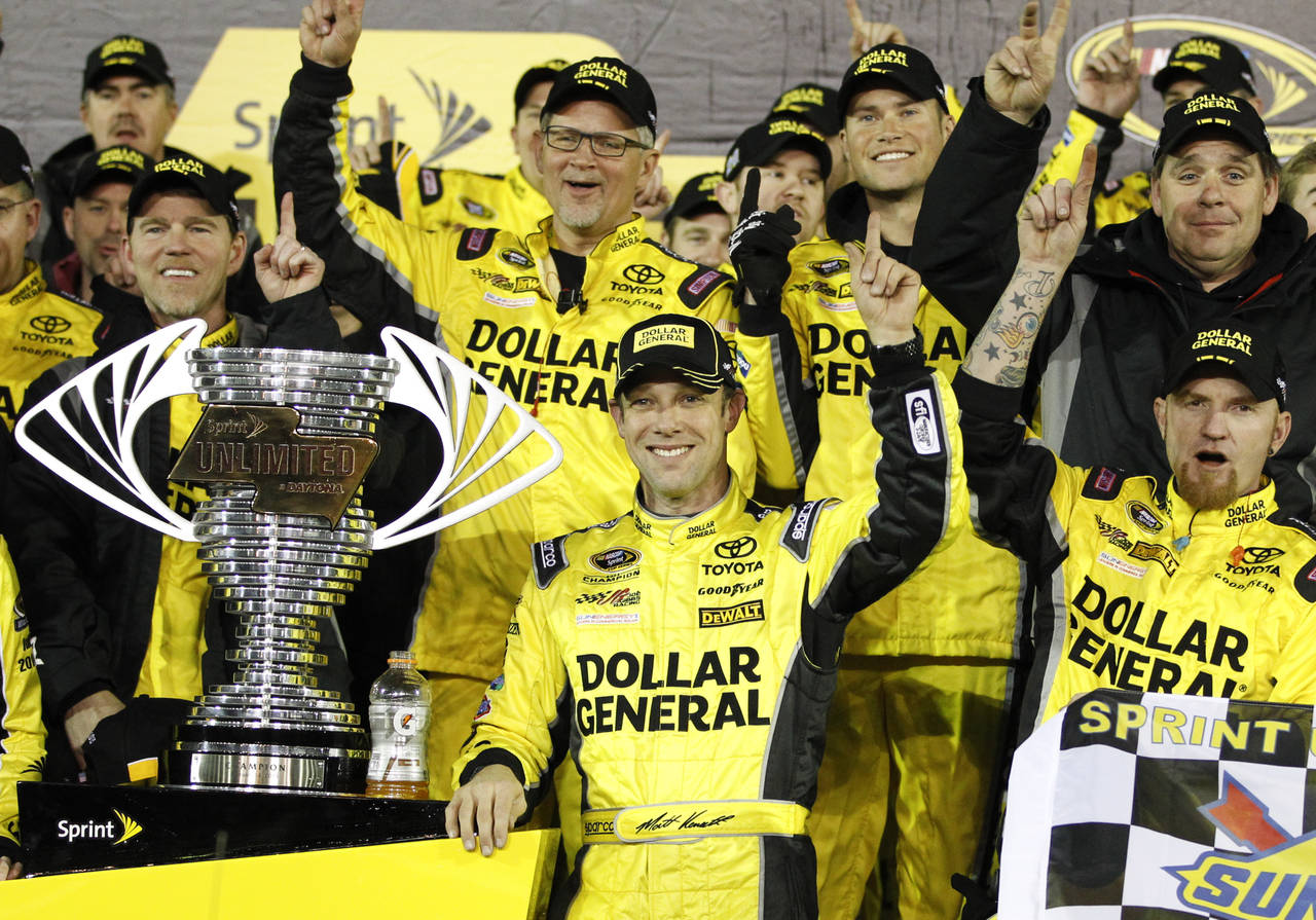 FILE - Matt Kenseth, center, stands next to the trophy in Victory Lane after winning the NASCAR Spr...