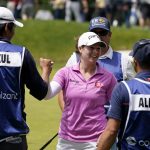 
              Ally Ewing, center, smiles on the 18th green after finishing her first round of the LPGA Cognizant Founders Cup golf tournament, Thursday, May 12, 2022, in Clifton, N.J. (AP Photo/Seth Wenig)
            