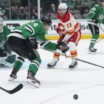 
              Dallas Stars defenseman Miro Heiskanen (4) and Calgary Flames left wing Johnny Gaudreau (13) chase after a loose puck in front of goaltender Jake Oettinger (29) in the second period of Game 4 of an NHL hockey Stanley Cup first-round playoff series, Monday, May 9, 2022, in Dallas. (AP Photo/Tony Gutierrez)
            