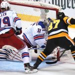 
              Pittsburgh Penguins' Sidney Crosby (87) pokes the puck under the pad of New York Rangers goaltender Igor Shesterkin (31) for a goal with K'Andre Miller (79) defending during the first period in Game 4 of an NHL hockey Stanley Cup first-round playoff series in Pittsburgh, Monday, May 9, 2022. (AP Photo/Gene J. Puskar)
            