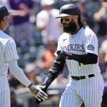
              Colorado Rockies' Yonathan Daza, left, congratulates Charlie Blackmon as he crosses home plate after hitting a solo home run off San Francisco Giants starting pitcher Logan Webb to leadoff the bottom of the first inning of a baseball game Wednesday, May 18, 2022, in Denver. (AP Photo/David Zalubowski)
            