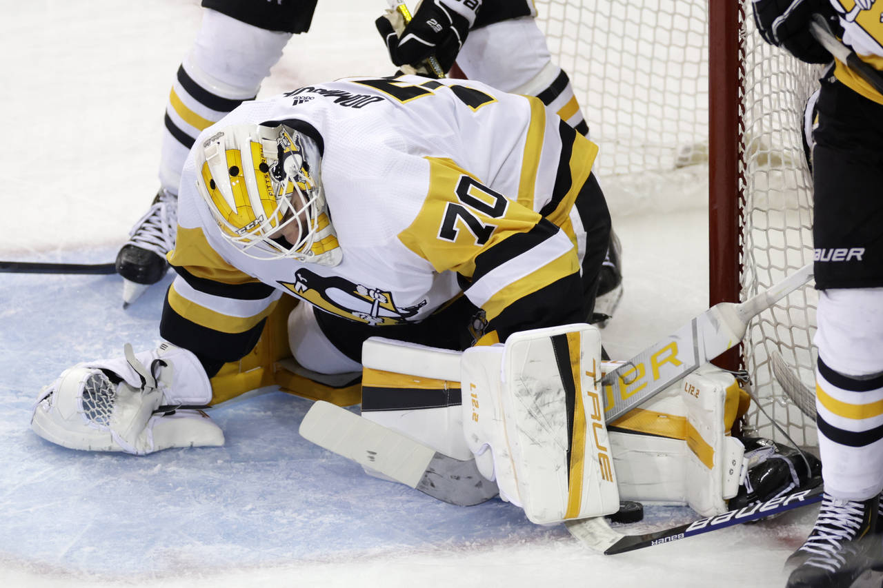 Pittsburgh Penguins goaltender Louis Domingue makes a save against the New York Rangers during the ...