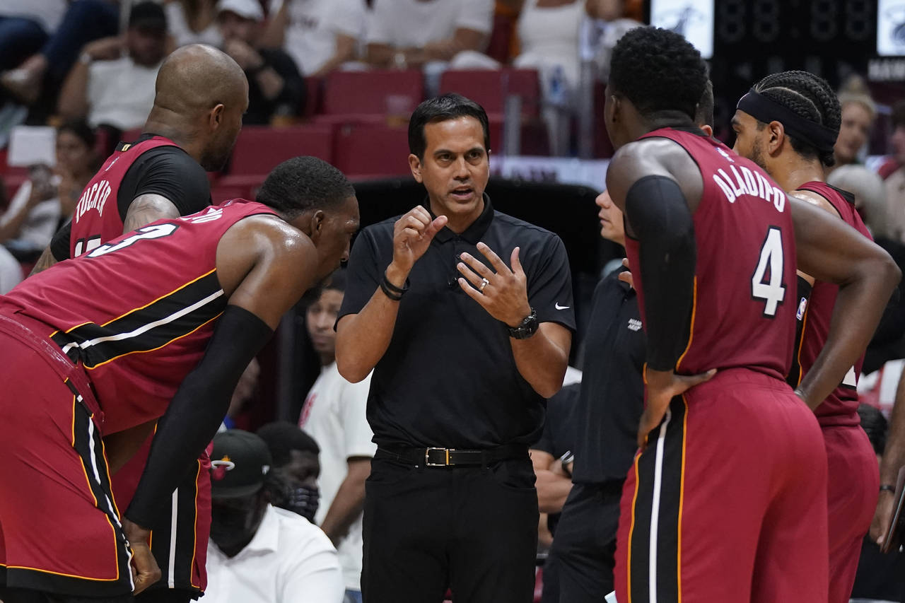 Miami Heat head coach Erik Spoelstra, center, talks with players as officials review a play during ...