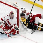
              Carolina Hurricanes' Ian Cole (28) falls onto Boston Bruins' Marc McLaughlin (26) behind Hurricanes goalie Antti Raanta (32) during the first period in Game 6 of an NHL hockey Stanley Cup first-round playoff series Thursday, May 12, 2022, in Boston. (AP Photo/Michael Dwyer)
            