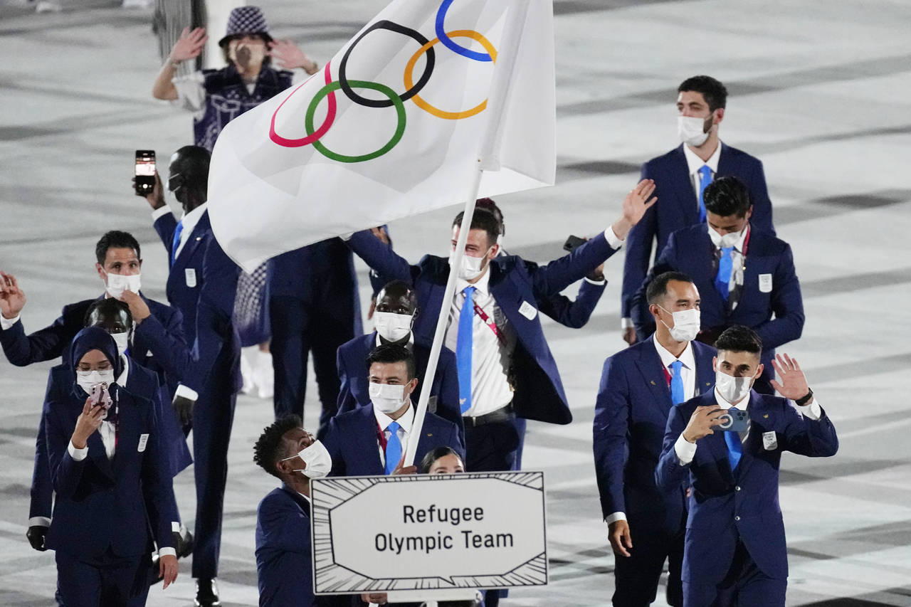 FILE - Yusra Mardini and Tachlowini Gabriyesos, of the Refugee Olympic Team, carry the Olympic flag...