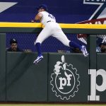 
              Texas Rangers center fielder Eli White hangs on the center field wall after catching a flyout by Tampa Bay Rays' Ji-Man Choi in the first inning of a baseball game, Monday, May 30, 2022, in Arlington, Texas. (AP Photo/Tony Gutierrez)
            