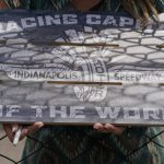 
              Kirstin Kendall holds a sign as she seeks autographs during practice for the Indianapolis 500 auto race at Indianapolis Motor Speedway, Monday, May 23, 2022, in Indianapolis. (AP Photo/Darron Cummings)
            