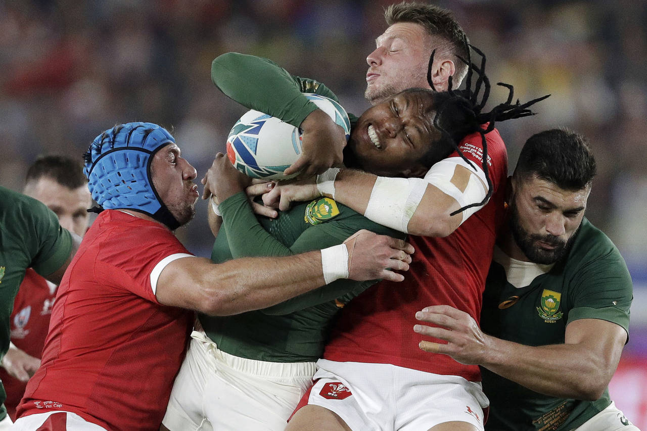 FILE - Wales' Dan Biggar, second right, tackles South Africa's S'Busiso Nkosi during the Rugby Worl...