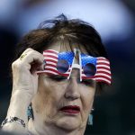 
              A fan adjusts flag-themed Memorial Day glasses during the first inning of a baseball game between the Arizona Diamondbacks and the Los Angeles Dodgers Sunday, May 29, 2022, in Phoenix. (AP Photo/Ross D. Franklin)
            