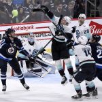 
              Seattle Kraken's Will Borgen (3) reaches for the bouncing puck as Winnipeg Jets' Pierre-Luc Dubois (80) watches it during the third period of NHL hockey game action in Winnipeg, Manitoba, Sunday, May 1, 2022. (Fred Greenslade/The Canadian Press via AP)
            