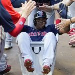 
              Boston Red Sox' Rafael Devers (11) is pushed through the dugout in a laundry cart as he celebrates after hitting a grand slam in the second inning of a baseball game against the Atlanta Braves Tuesday, May 10, 2022, in Atlanta. (AP Photo/John Bazemore)
            