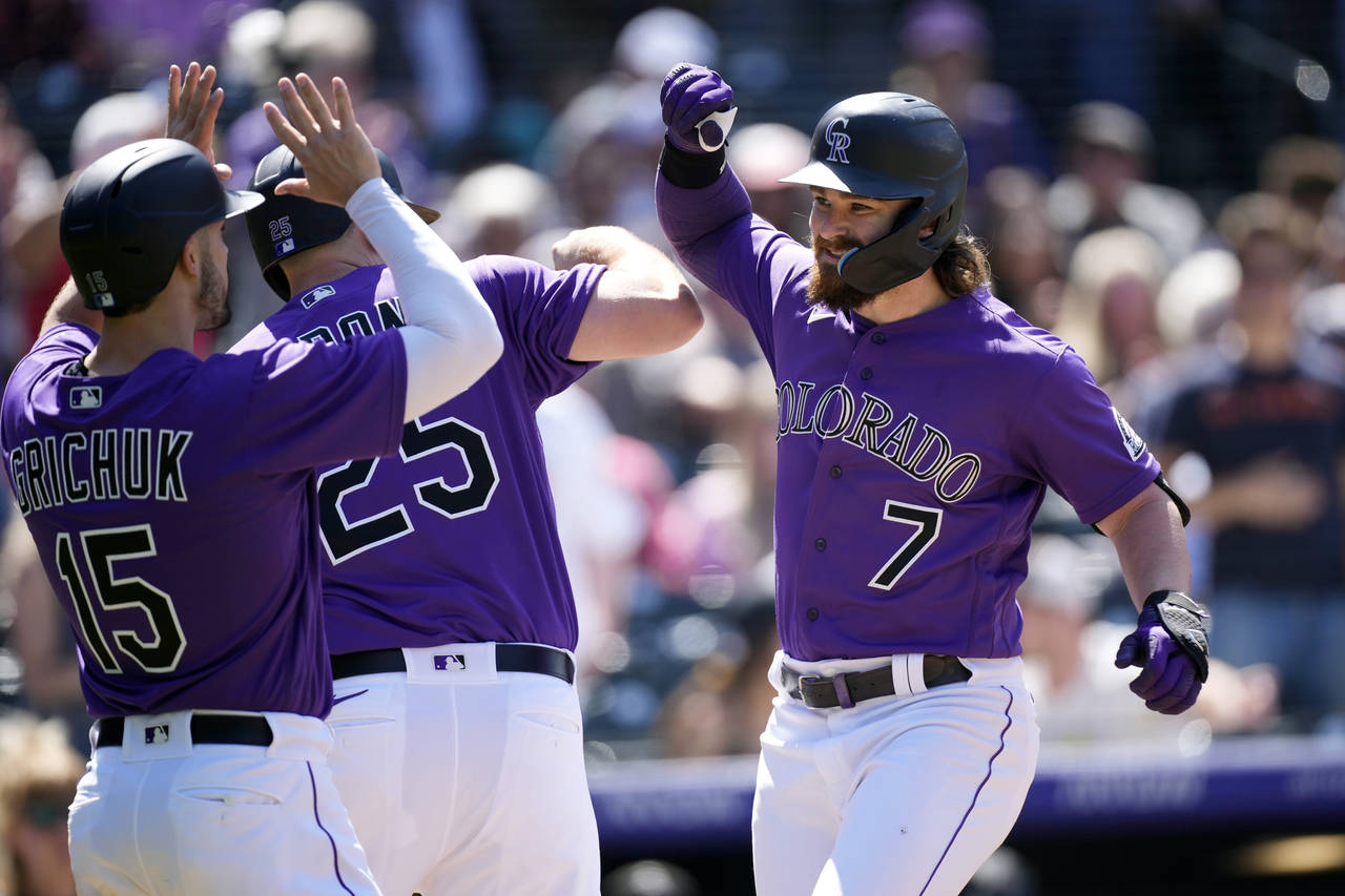 Colorado Rockies' Brendan Rodgers, right, celebrates with C.J. Cron, center, and Randal Grichuk aft...