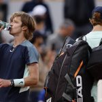 
              Russia's Andrey Rublev drinks as Italy's Jannik Sinner leaves the court as he withdraws during their fourth round match of the French Open tennis tournament at the Roland Garros stadium Monday, May 30, 2022 in Paris. (AP Photo/Jean-Francois Badias)
            