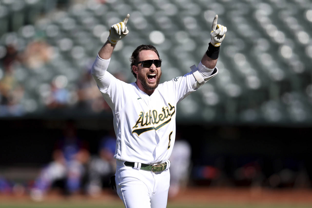 Oakland Athletics' Jed Lowrie celebrates after his winning RBI-single against the Texas Rangers dur...