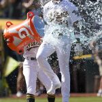 
              Oakland Athletics' Luis Barrera, top, jumps through Gatorade thrown by Tony Kemp, rear, after hitting a three-run home run against the Los Angeles Angels during the ninth inning of the first baseball game of a doubleheader in Oakland, Calif., Saturday, May 14, 2022. (AP Photo/Jeff Chiu)
            