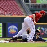 
              Cincinnati Reds' Mike Moustakas, top, tags out Milwaukee Brewers' Kolten Wong as he attempts to steal third base during the first inning of a baseball game in Cincinnati, Wednesday, May 11, 2022. (AP Photo/Aaron Doster)
            
