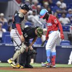 
              Miami Marlins Jazz Chisholm Jr., right, and Atlanta Braves catcher Travis d'Arnaud, left, check on home plate umpire Jansen Visconti after he was struck by a foul ball during the first inning of a baseball game Saturday, May 21, 2022, in Miami. (AP Photo/Gaston De Cardenas)
            