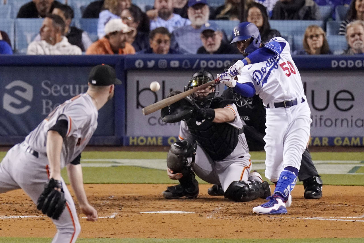 Los Angeles Dodgers right fielder Mookie Betts, right, hits a solo home run as San Francisco Giants...