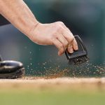 
              Home plate umpire Sean Barber sweeps dirt from home plate in the first inning of a baseball game between the Colorado Rockies and the Washington Nationals, Thursday, May 26, 2022, in Washington. (AP Photo/Patrick Semansky)
            