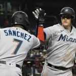 
              Miami Marlins' Garrett Cooper, right, is greeted with a high-five from Jesus Sanchez after hitting a home run against the Arizona Diamondbacks during the fourth inning of a baseball game Monday, May 9, 2022, in Phoenix. (AP Photo/Darryl Webb)
            
