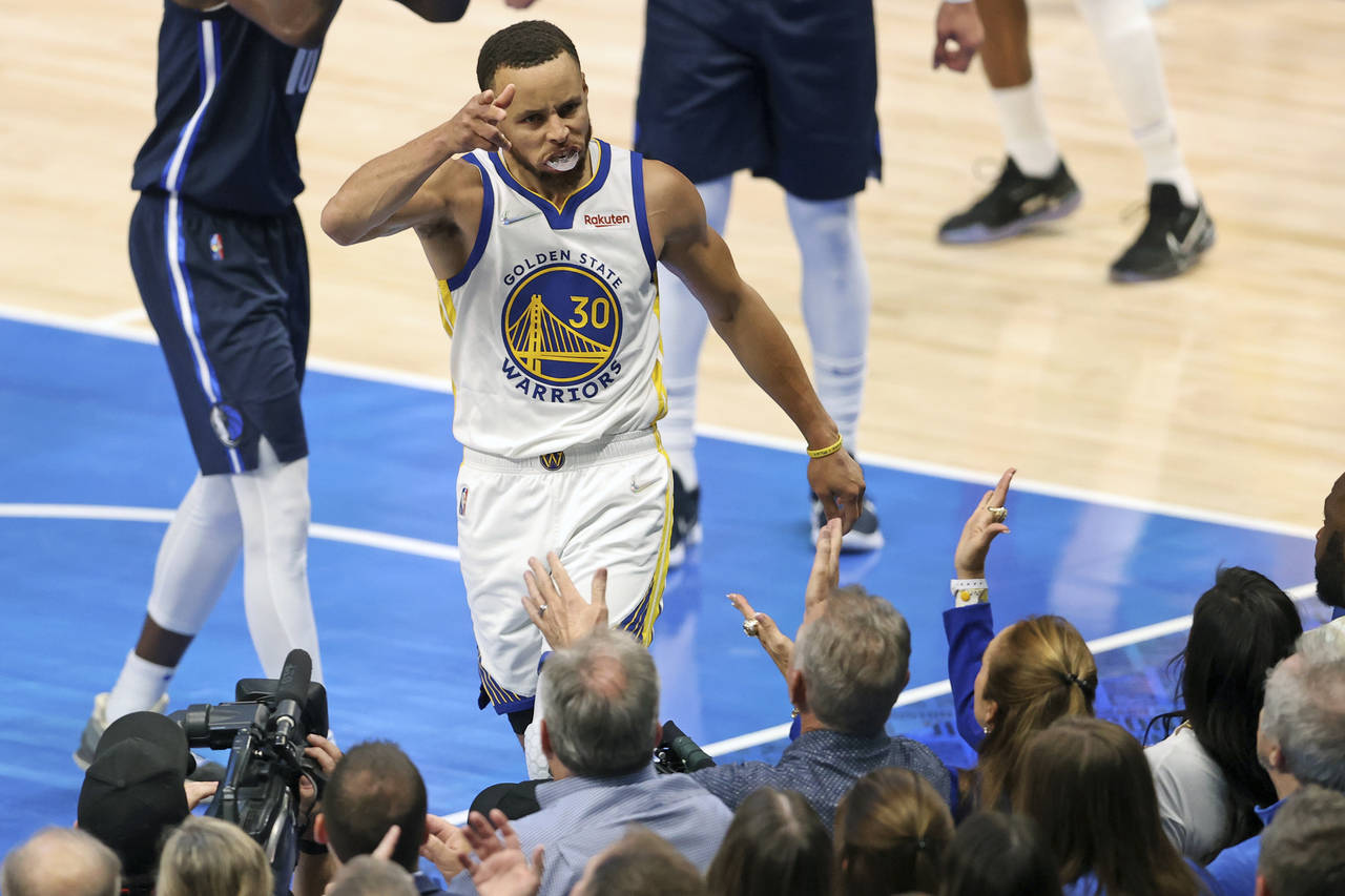 Golden State Warriors' Stephen Curry celebrates a basket and a Dallas Mavericks' foul during the fi...