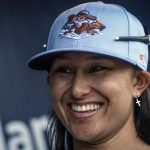 
              Kelsie Whitmore, a 23-year-old two-way player for the Atlantic League's Staten Island FerryHawks, smiles in her team’s dugout before gametime, Friday, May 13, 2022, in New York. Whitmore is one of the first women to be in the starting lineup and pitch relief with a professional team connected to Major League Baseball. (AP Photo/Bebeto Matthews)
            
