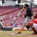 
              Milwaukee Brewers' Christian Yelich hits a ground-rule double during the first inning of a baseball game against the Cincinnati Reds in Cincinnati, Wednesday, May 11, 2022. (AP Photo/Aaron Doster)
            
