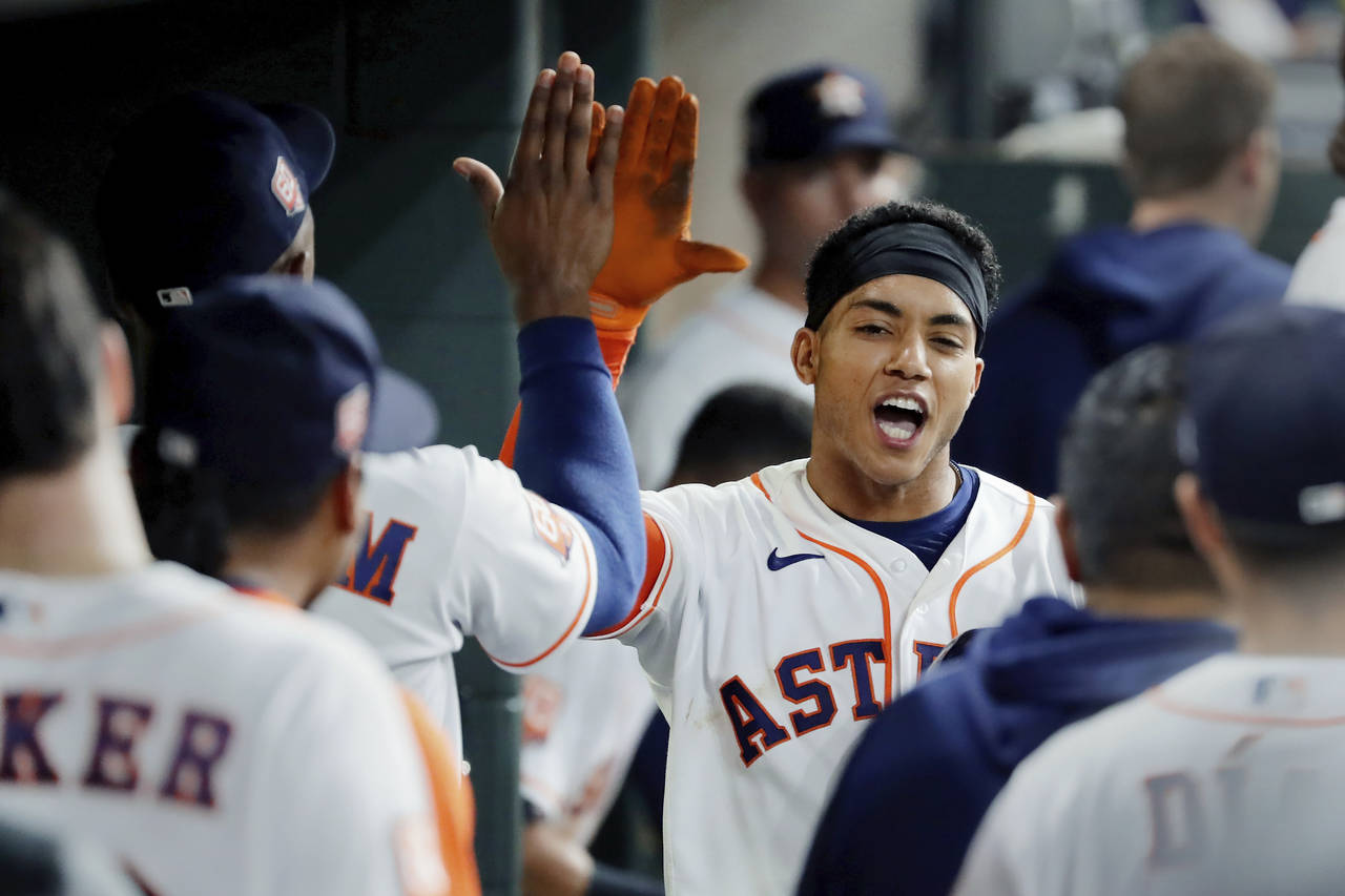 Houston Astros' Jeremy Pena, right, collects high-fives in the dugout after his home run against th...