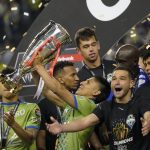 
              United States' Seattle Sounders forward Raul Ruidiaz holds the trophy alongside teammate midfielder Nicolás Lodeiro after the Sounders defeated Mexico's Pumas to win the CONCACAF Champions League soccer final Wednesday, May 4, 2022, in Seattle. (AP Photo/Ted S. Warren)
            